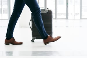 Man walking through airport with suitcase