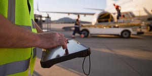 Worker on airport runway with tablet