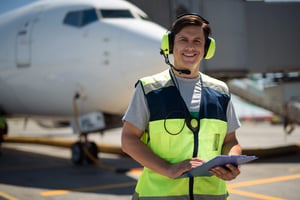 Man working on an airfield holding a clipboard